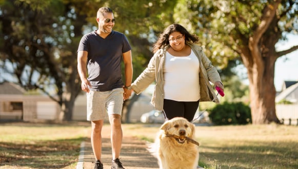 A man and a woman walking with dog