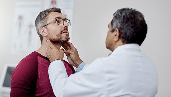 Doctor checking man's glands