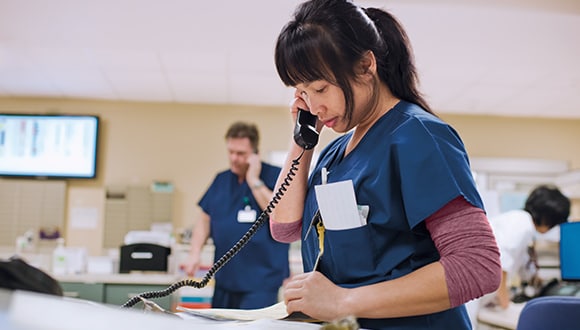 Nurse at a hospital reception desk on the phone