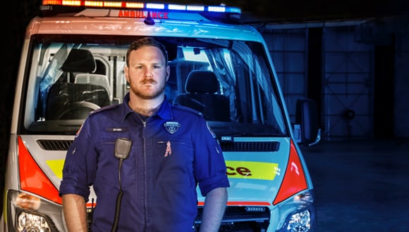 Paramedic standing in front of ambulance