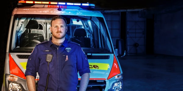 Paramedic standing in front of an ambulance