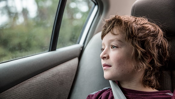 Can a child have depression? Young boy looking out a car window.