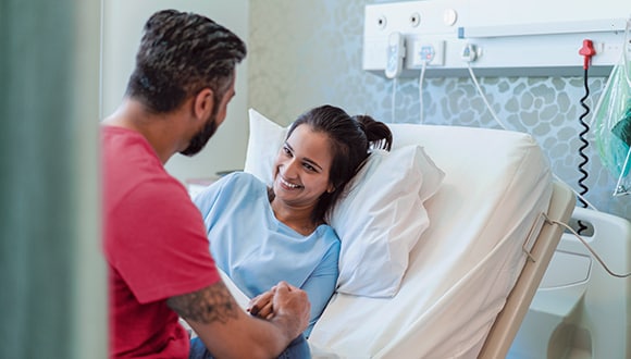 Man keeping woman company while she is in hospital