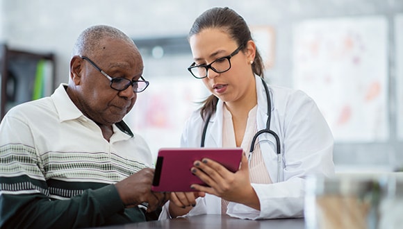 Nurse with a man monitoring his bowel cancer
