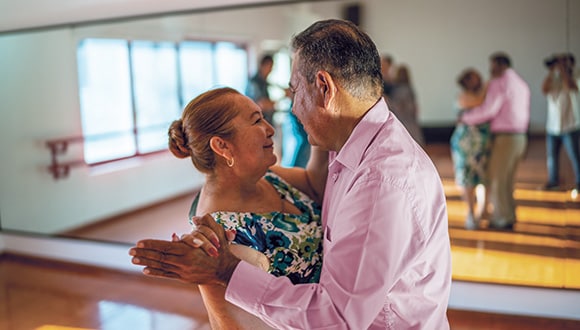 Woman and man dancing together to help lower blood pressure