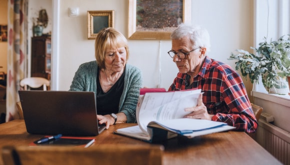 Man and woman sitting down in front of a laptop
