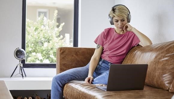 Lady sitting on a lounge looking sad while dealing with anxiety