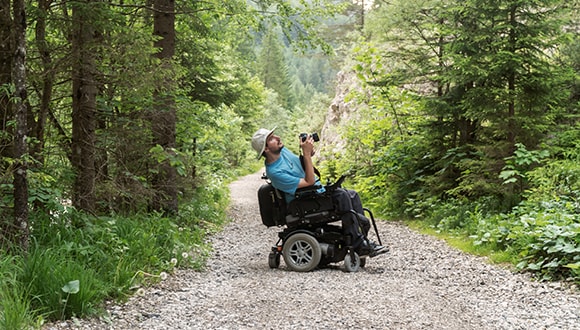 Man in a wheelchair travelling through the wilderness