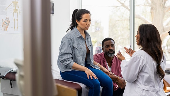 a couple talking to a doctor about infertility