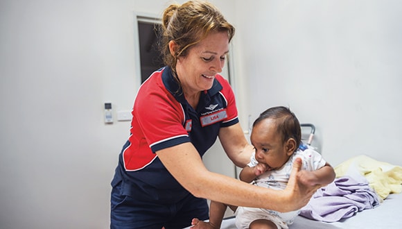 a nurse holding an infant child